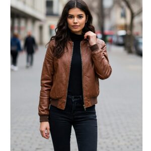A woman wearing a brown leather bomber jacket styled with black jeans and turtleneck.