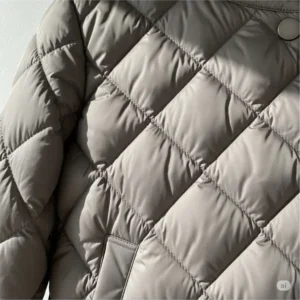 Close-up detail of the classic diamond quilting pattern on a lightweight quilted jacket, highlighting the quality craftsmanship.