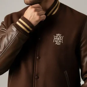 Brown varsity jacket featuring subtle embroidered details on the chest, adding a personalized touch to the classic design