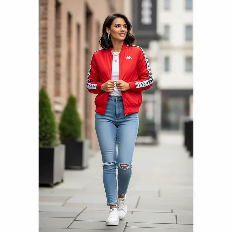A woman sporting a trendy Kappa bomber jacket in a vibrant color, paired with jeans, demonstrating the versatility and modern appeal of Kappa apparel for women.