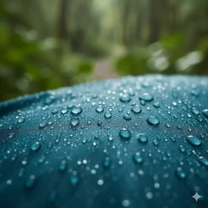 Close-up of water droplets beading on the surface of a women's lightweight hooded rain jacket.