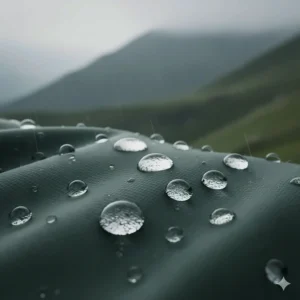 Close-up of water droplets beading on the surface of an affordable hard shell hiking jacket with DWR coating.