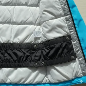 The internal elastic snow skirt (powder gaiter) fastened inside the youth snowboard jacket to prevent snow from entering.