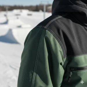 Close-up of reinforced stitching on a durable snowboard jacket designed for park rail progression.