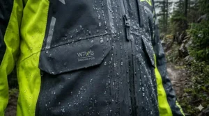 Close-up illustration of water beads rolling off the breathable, waterproof fabric of a dirt bike rain jacket.