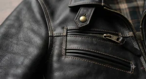 Macro shot of high-quality stitching and hardware on a premium leather jacket, proving why it is the best leather jacket for men.