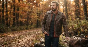 A man wearing a rugged, distressed brown leather jacket outdoors, illustrating the durable design of the best leather jacket for men for fall fashion.
