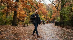 A man wearing a classic denim jacket men style during an autumn park walk