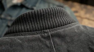 Macro shot highlighting the durable nylon fabric and knit collar of a traditional ma-1 bomber jacket.