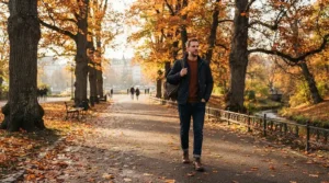 Man wearing a sherpa lined denim jacket men during a crisp autumn walk in a city park