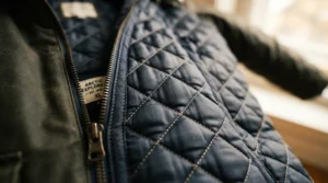 Detailed view of a warm quilted liner inside a heavy military parka men for cold weather.